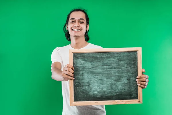 Asyalı genç adam boş bir tahtayla gülümseyen mutluluğu sunuyor. — Stok fotoğraf