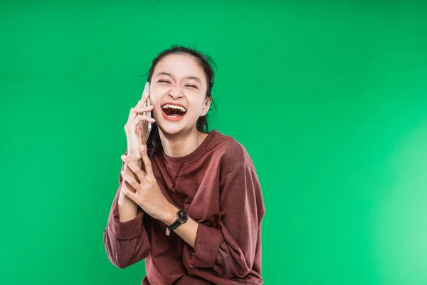 Vacker ung asiatisk kvinna talar i telefon med uttryck skratta glatt — Stockfoto