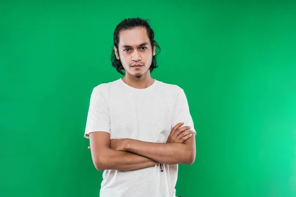 Portrait of a handsome Asian man with a serious expression with his arms crossed — Stock Photo, Image