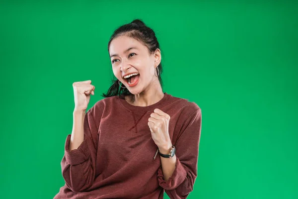 Asiatisk ung flicka som uttrycker ansikte lycka med knuten i knytnävarna och höjde två händer — Stockfoto