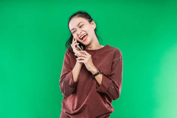 젊은 여자가 누군가와 행복하게 웃으면서 전화를 하고 있다 — 스톡 사진