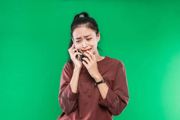 아시아인젊은 여성 이 손으로 턱을 잡고 울면서 충격받은 표정으로 전화로 이야기하는 모습 — 스톡 사진