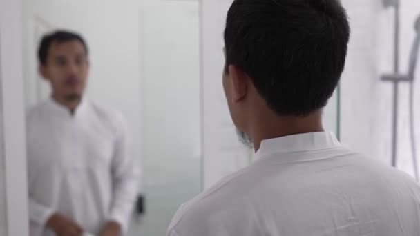 Musulmano asiatico uomo guardando specchio e ottenere vestito — Video Stock