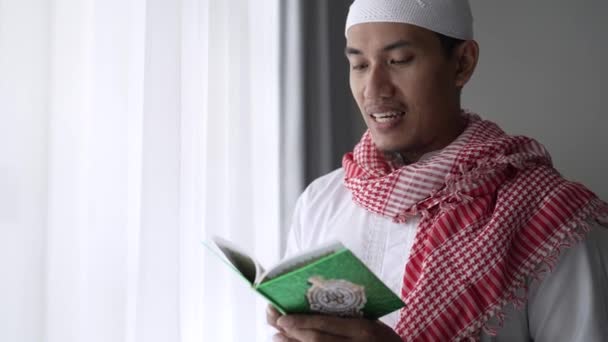 Asiatischer religiöser Mann liest im Stehen Koran oder Qran — Stockvideo