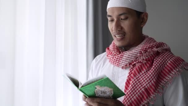 Aziatische religieuze man het lezen van koran of koran terwijl staande — Stockvideo