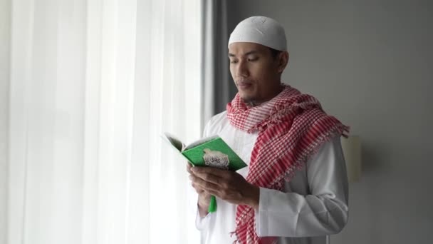 Azjatycki religijny człowiek czyta koran lub Koran podczas stojąc — Wideo stockowe