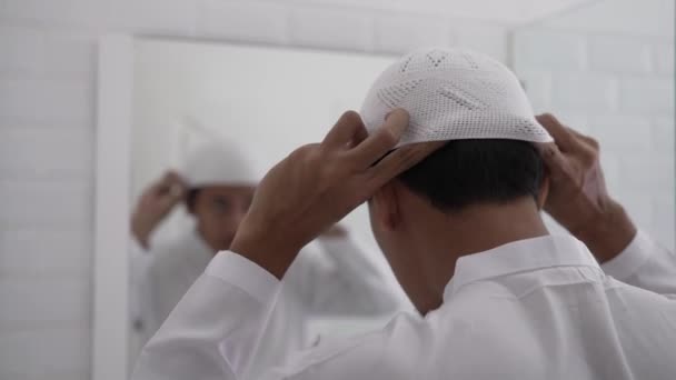 Pria muslim asia melihat cermin dan berpakaian sebelum pergi ke masjid — Stok Video