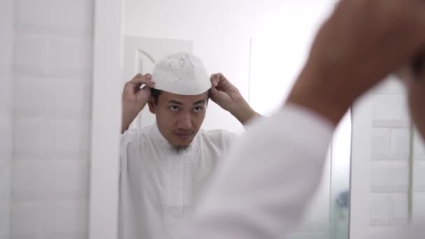 Muslimsk asiatisk man tittar på spegeln och klä på sig innan du går till moskén — Stockvideo