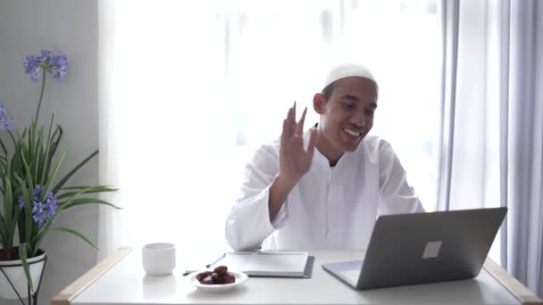 アジア系イスラム教徒の男性がビデオ通話会議のためにノートパソコンを使って — ストック動画