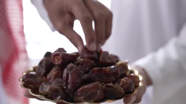 Muslime nehmen Dattelfrüchte beim gemeinsamen Iftar-Abendessen im Ramadan entgegen — Stockvideo