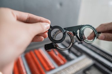 Bir doktorun eli bir odada deneysel lens çerçevesini tutuyor.
