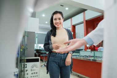 Güzel bir kadın, garson onu el hareketiyle karşıladığında yürür.