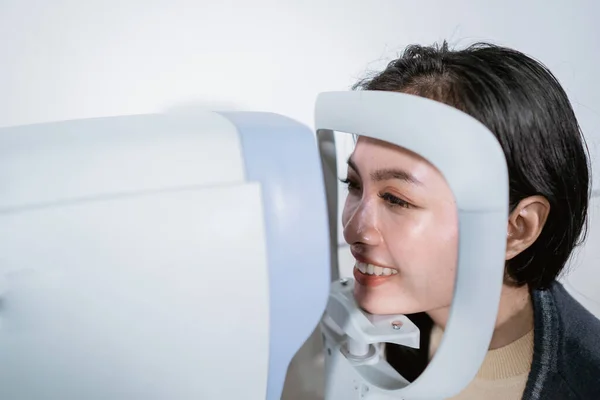 Une femme subit un examen à l'aide d'un ordinateur d'examen oculaire — Photo