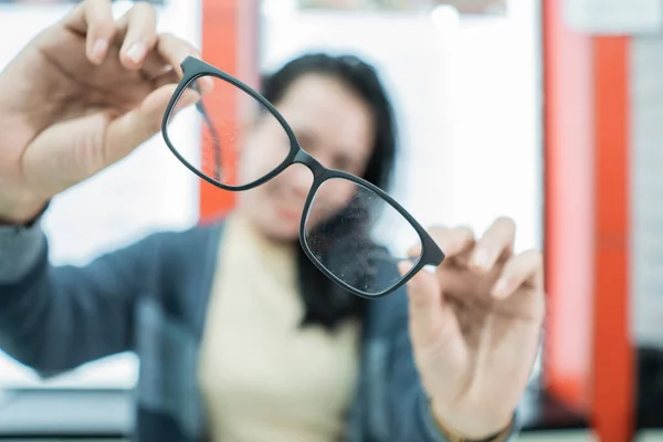 En vacker kvinna som håller ett prov av glasögon — Stockfoto