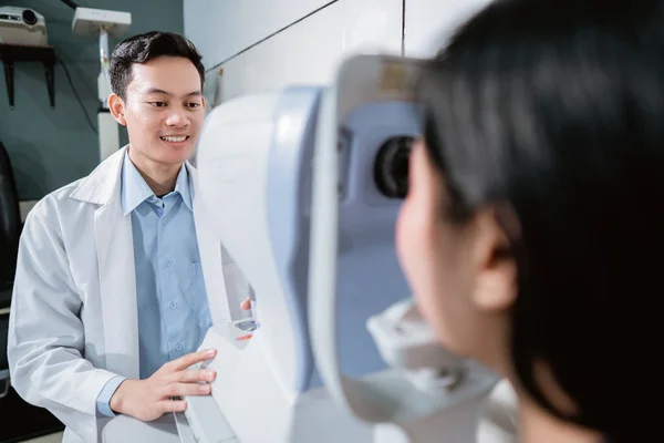 Een arts onderzoekt een vrouwelijke patiënt met behulp van een oogcomputer — Stockfoto