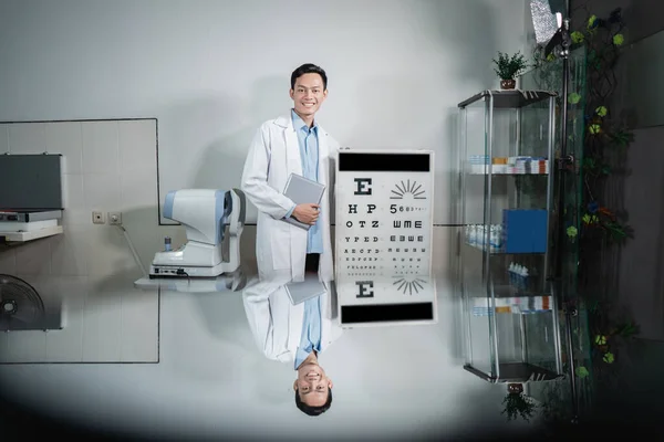Un medico di sesso maschile in posa accanto a un kit di test oculistici — Foto Stock