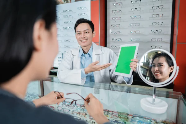 Un médico masculino está mostrando un tablero de pruebas de color que es uno de los fundamentos de los exámenes oculares —  Fotos de Stock