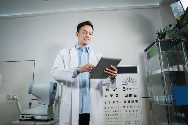 Egy férfi orvos szemészeti ellenőrző listát vezet, amely a vizsgálatok alapját képezi — Stock Fotó