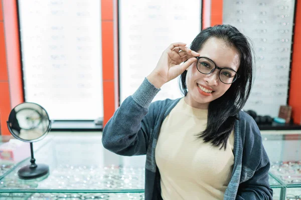 Una bella donna che indossa occhiali di sua scelta e posa davanti a una finestra di occhiali — Foto Stock