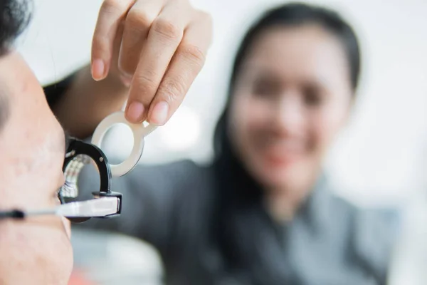 En kvinnlig ögonläkare på en försöksram när han / hon är med patienten — Stockfoto