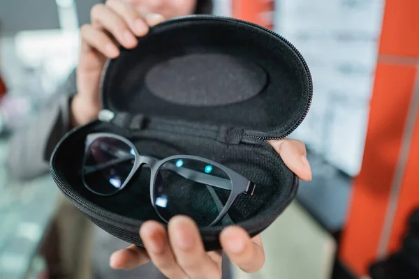 La mano sostiene las gafas en el protector de gafas —  Fotos de Stock