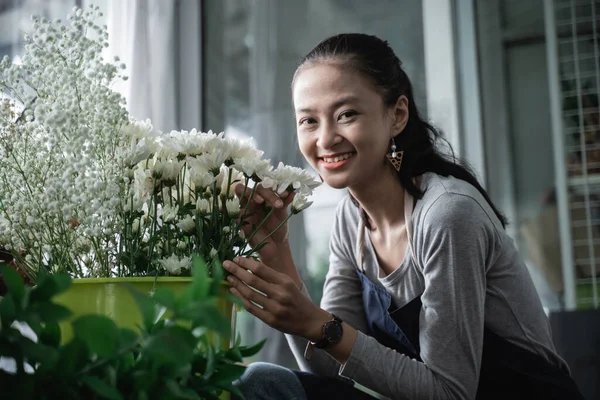 Счастливая женщина флорист в фартуке, который пахнет красивым букетом. — стоковое фото