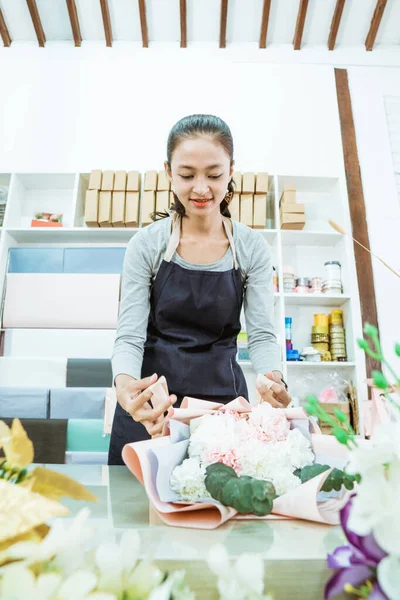 Jonge vrouw bloemist werken in bloem winkel voorbereiding orde flanel bloem — Stockfoto