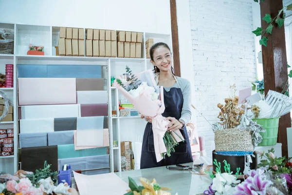 Gelukkig jong vrouw bloemist werken in bloem winkel holding flanel bloem — Stockfoto