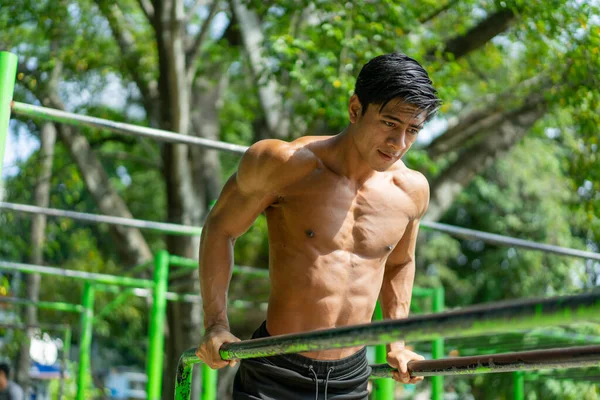 Un homme musclé qui tire vers le haut pour travailler ses muscles biceps et triceps — Photo