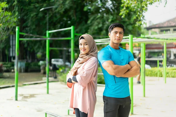 Muslim couples stand back to back with crossed hands — Stock Photo, Image