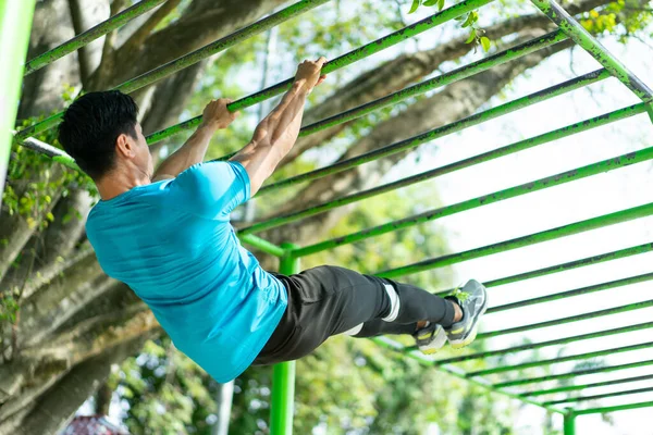 Un hombre musculoso en ropa de gimnasio haciendo ejercicios de mano perfecta pull-up para la fuerza de escalada — Foto de Stock