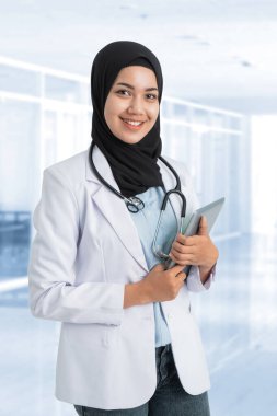 Beyaz önlüklü Müslüman kadın doktor.