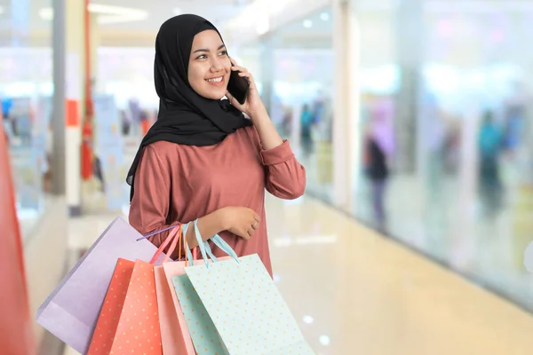 Muçulmano jovem mulher de compras fazer um telefonema — Fotografia de Stock