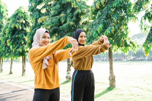 2人の邪悪なイスラム教徒の女の子はジョギングやアウトドアスポーツの前に手を伸ばし — ストック写真