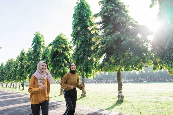 2人の幸せなイスラム教徒の女の子でスカーフは屋外スポーツをしながらジョギング — ストック写真