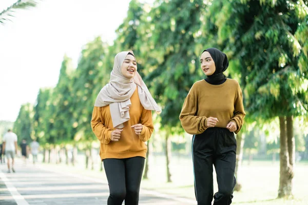 Twee mooie meisjes in sluier doen outdoor sport terwijl joggen samen — Stockfoto