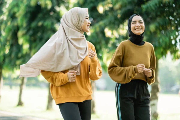 Dvě dospívající dívky v závoji dělat venkovní sporty při jogging spolu — Stock fotografie