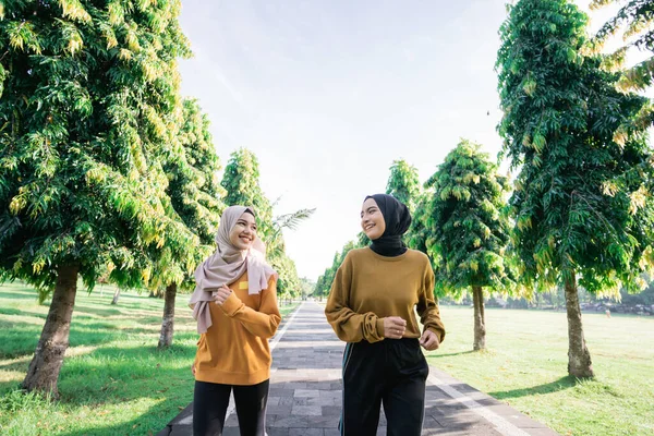Duas meninas adolescentes muçulmanas em véu fazendo esportes ao ar livre juntos pouco antes de quebrar o rápido — Fotografia de Stock