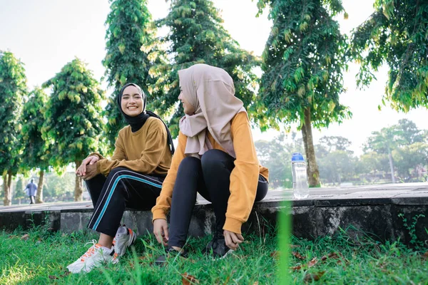 Dos chicas con hijab sonriendo y disfrutar de la tarde después de hacer ejercicio juntos —  Fotos de Stock