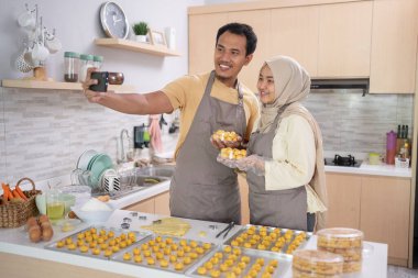 Müslüman çift evde yapılan yemeklerle selfie çekiyor.