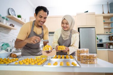 Müslüman çift, Ramazan 'da mutfakta birlikte nastarlı kek yapıyor.