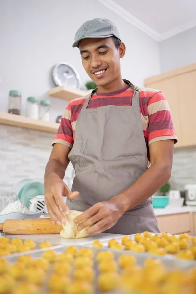 Aziatische jong man bakken nastar snack thuis — Stockfoto