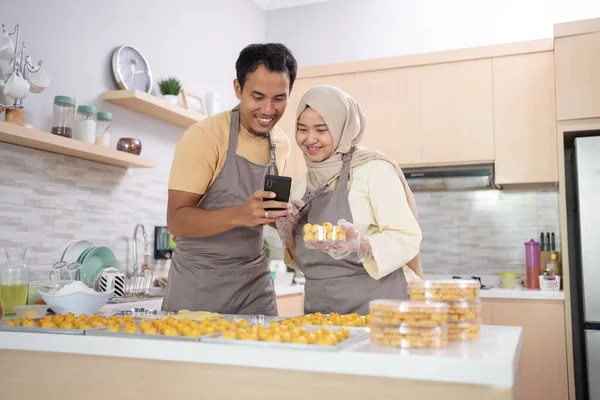 Muslimský pár použít mobilní telefon na podporu jejich produkt svačinky pro Eid — Stock fotografie