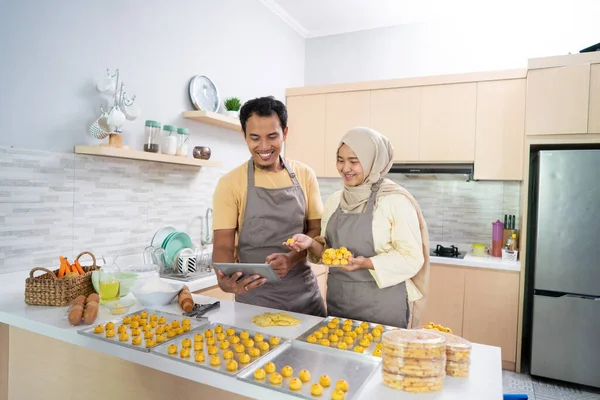 穆斯林夫妇与平板电脑烘焙蛋糕，在拉面销售 — 图库照片