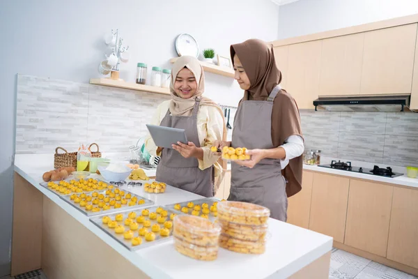 Muslim žena drží tablet PC při pečení nastar dort doma — Stock fotografie