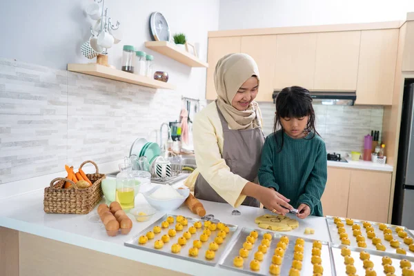 Ibu muslim selama kegiatan ramadan dengan putrinya membuat kue nastar bersama-sama — Stok Foto