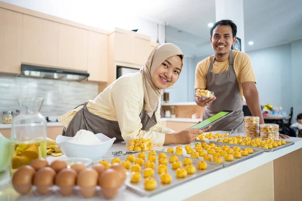 Мусульманська пара з планшетним ПК випікає торт на продаж під час Рамадана — стокове фото