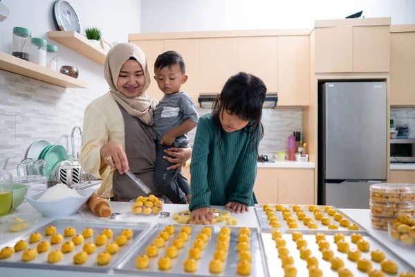 Wanita muslim muda dengan dua anaknya memasak di dapur bersama-sama — Stok Foto