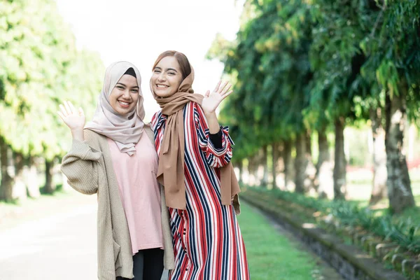 Mulheres muçulmanas em hijabs ao ar livre no dia ensolarado com amigo feliz — Fotografia de Stock