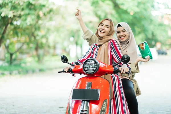 Gelukkig moslim meisjes paardrijden scooter genieten zomer vakantie — Stockfoto